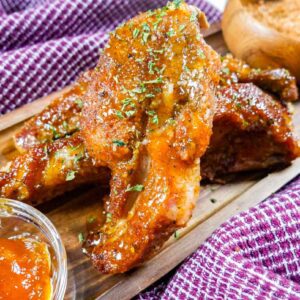 Apricot glazed ribs on wooden board with glaze and Adam's dry rub