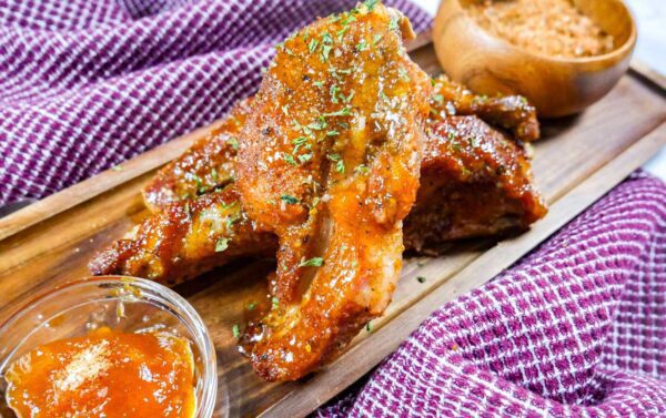 Apricot glazed ribs on wooden board with glaze and Adam's dry rub