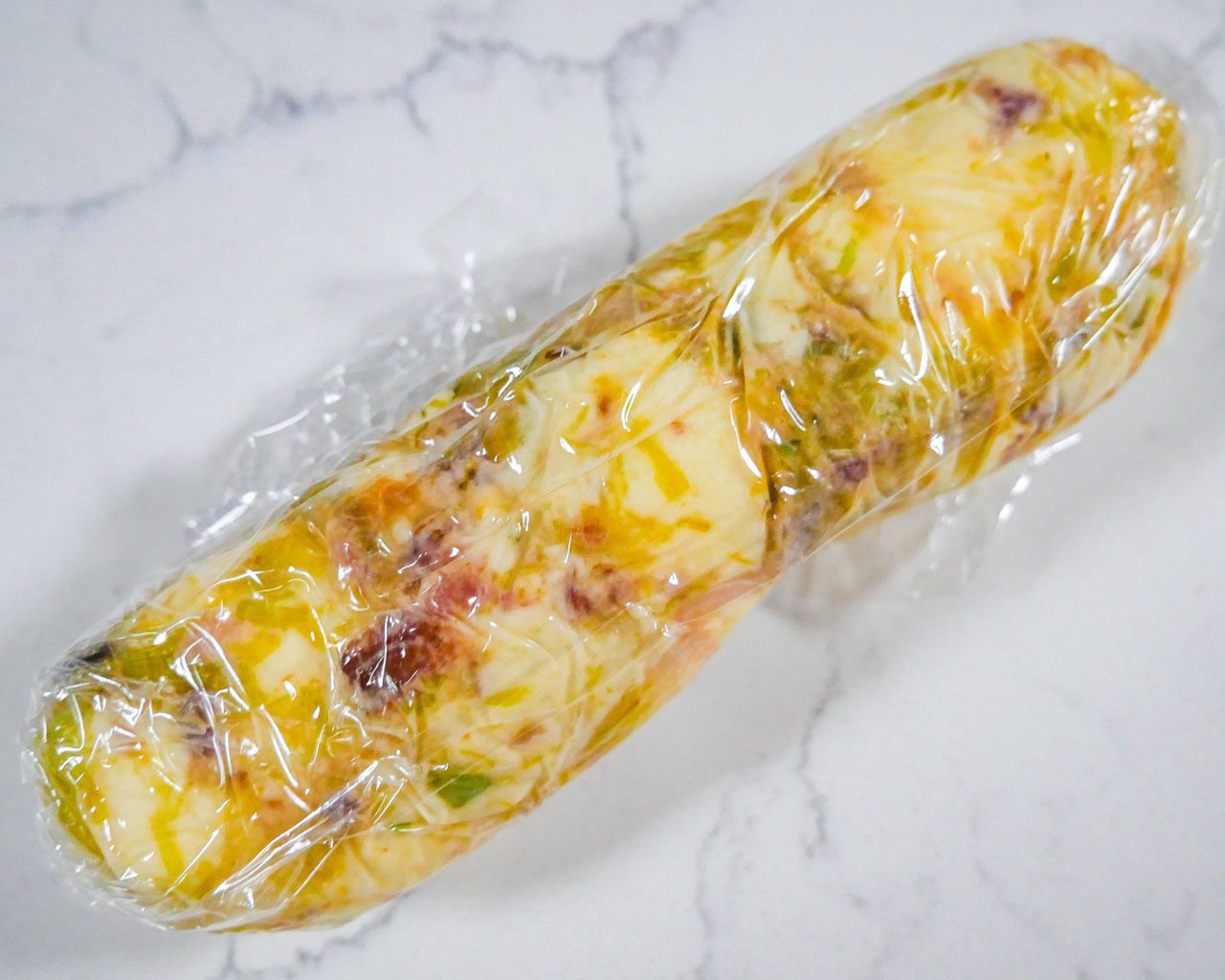 Leek and bacon compound butter rolled in cling wrap
