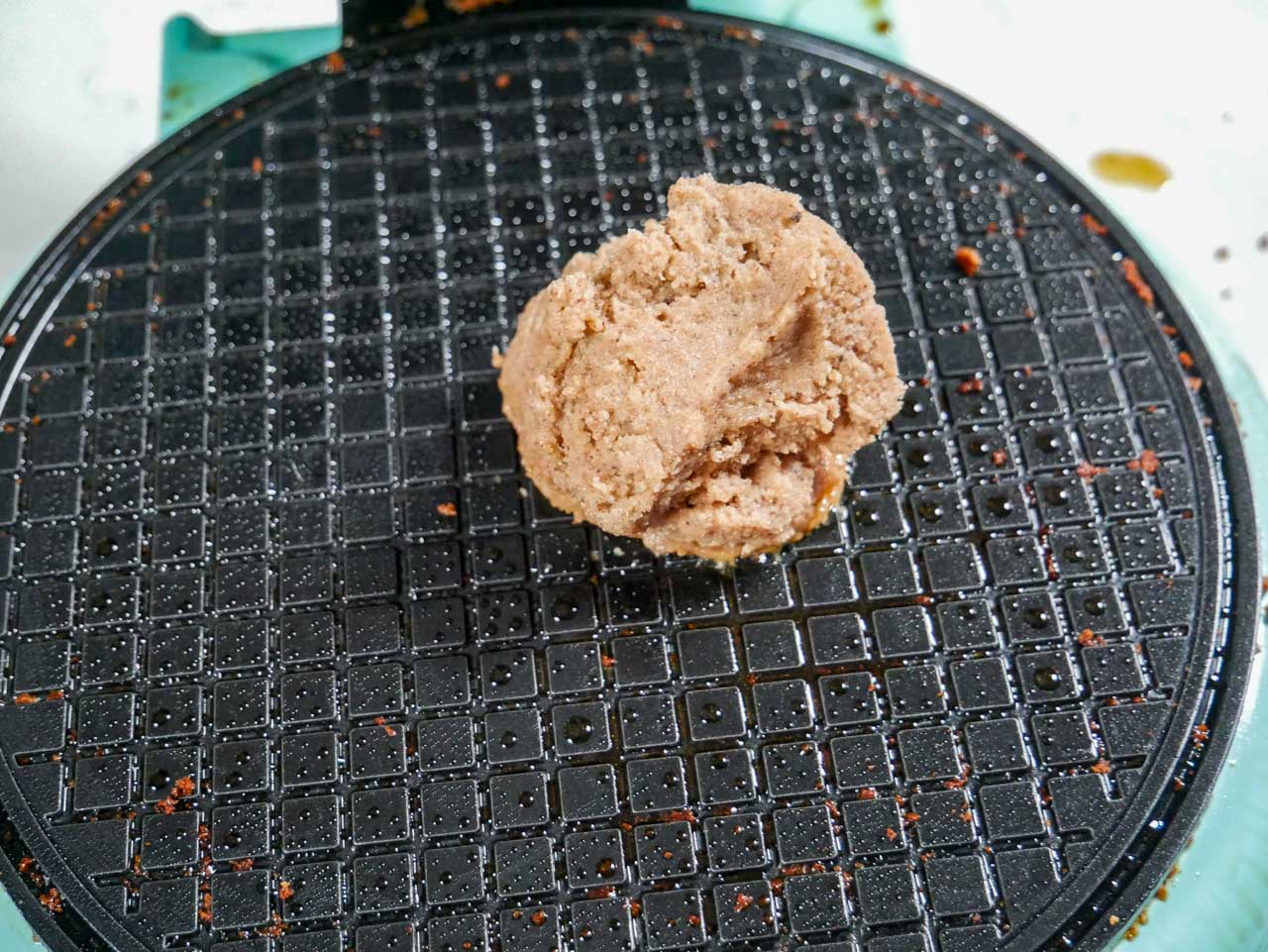 Homemade gingerbread ball on waffle iron before waffle is made