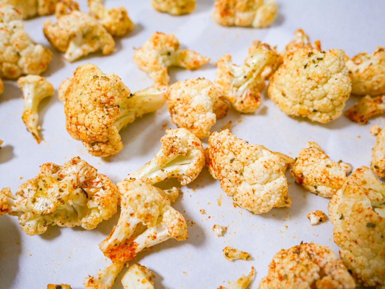 Cauliflower cut and seasoned on a baking sheet