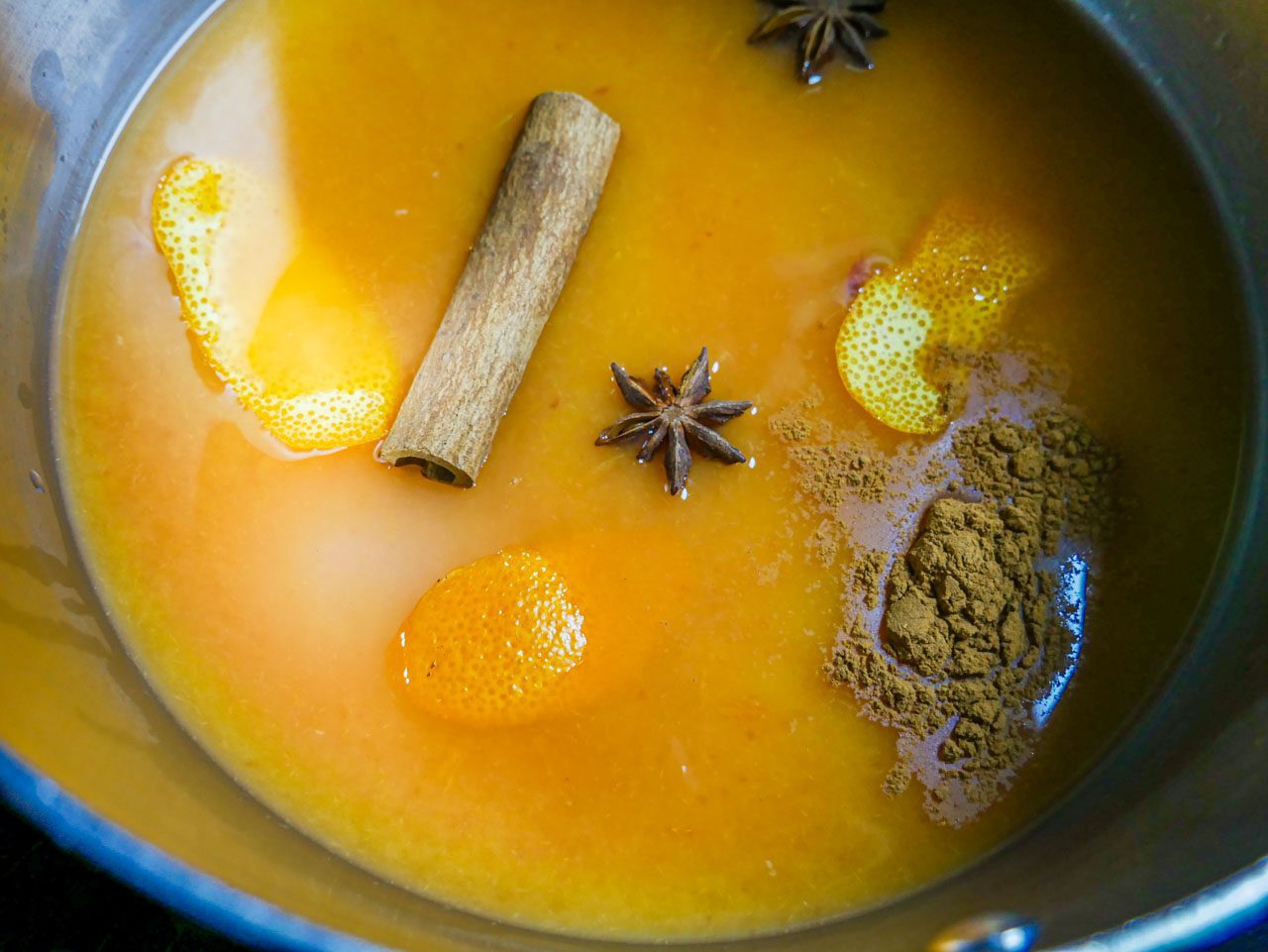 Blood orange, orange juice and spices in a pot before cranberries are added