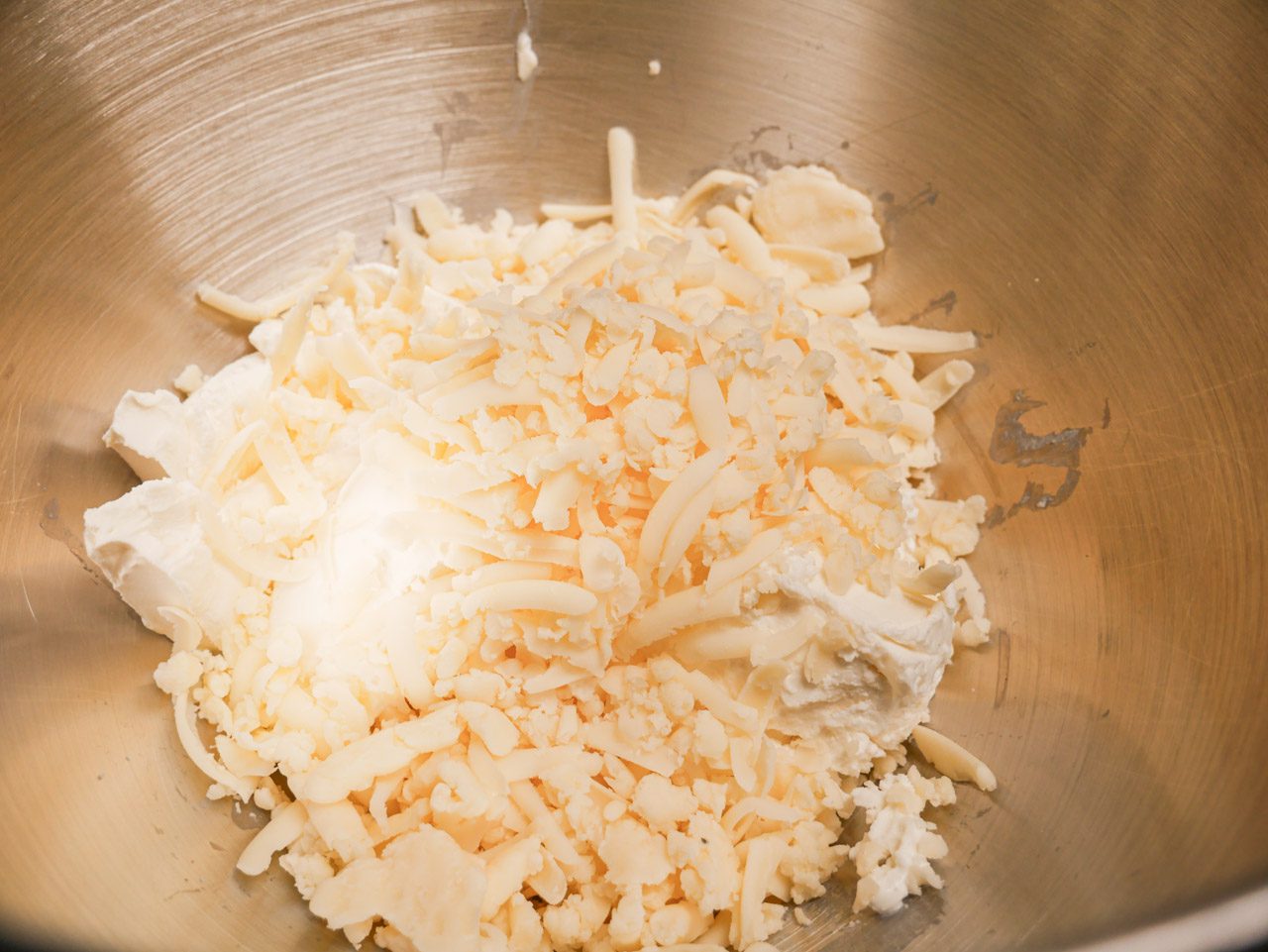 Cheddar, cream, and goat cheese in a bowl