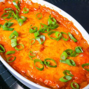 BBQ chicken casserole in an individual casserole dish with green onion topping