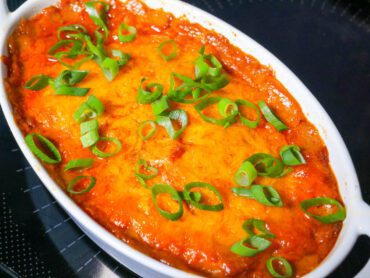 BBQ chicken casserole in an individual casserole dish with green onion topping