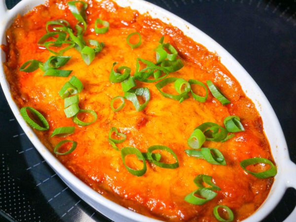 BBQ chicken casserole in an individual casserole dish with green onion topping