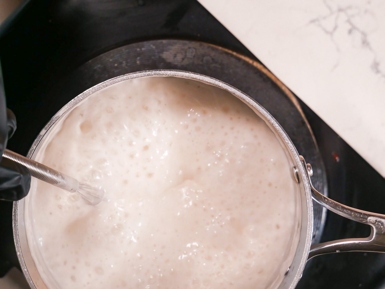 Agar Agar mixture with coconut milk bubbling in a saucepan.