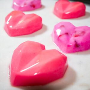 Coconut and Fruit Jelly Heart with Agar Agar on top of white marbled surface