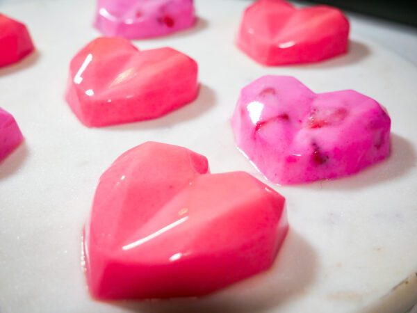 Coconut and Fruit Jelly Heart with Agar Agar on top of white marbled surface