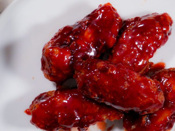 Chicken wings in a bowl coated in sweet sriracha sauce