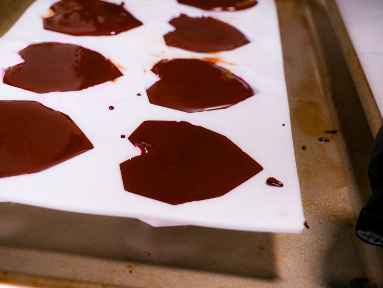 Chocolate poured on top of the fruit jelly and marshmallow fluff in heart-shaped silicone mold.