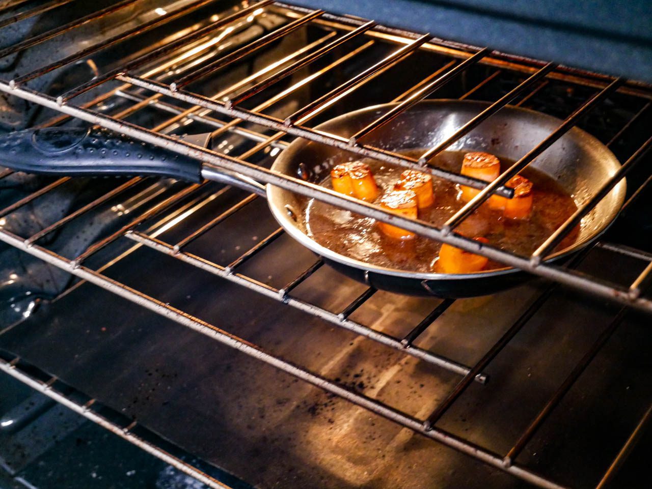 Sweet potato fondants in a frying pan that is placed in an oven to cook further