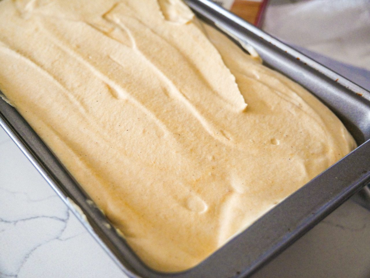 Sweet potato condensed milk mixture spread into loaf pan.