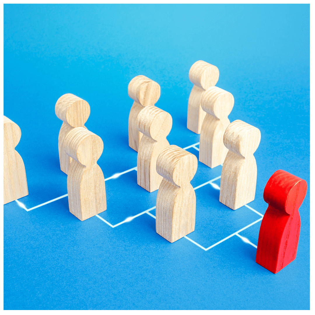 One red wooden figurine against several natural wood ones on a family chart against a sky blue background