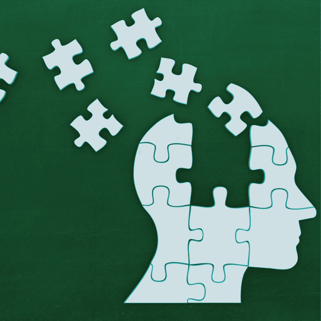 A puzzle of a human head with missing pieces scattered above against a dark green background