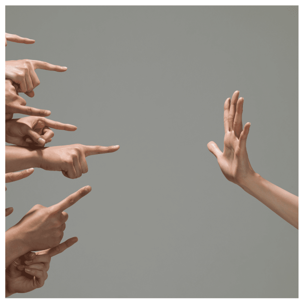 One hand is in a stop position on one side, and several hands are pointing on the other side. Against a gray backdrop. Take the people pleaser test.