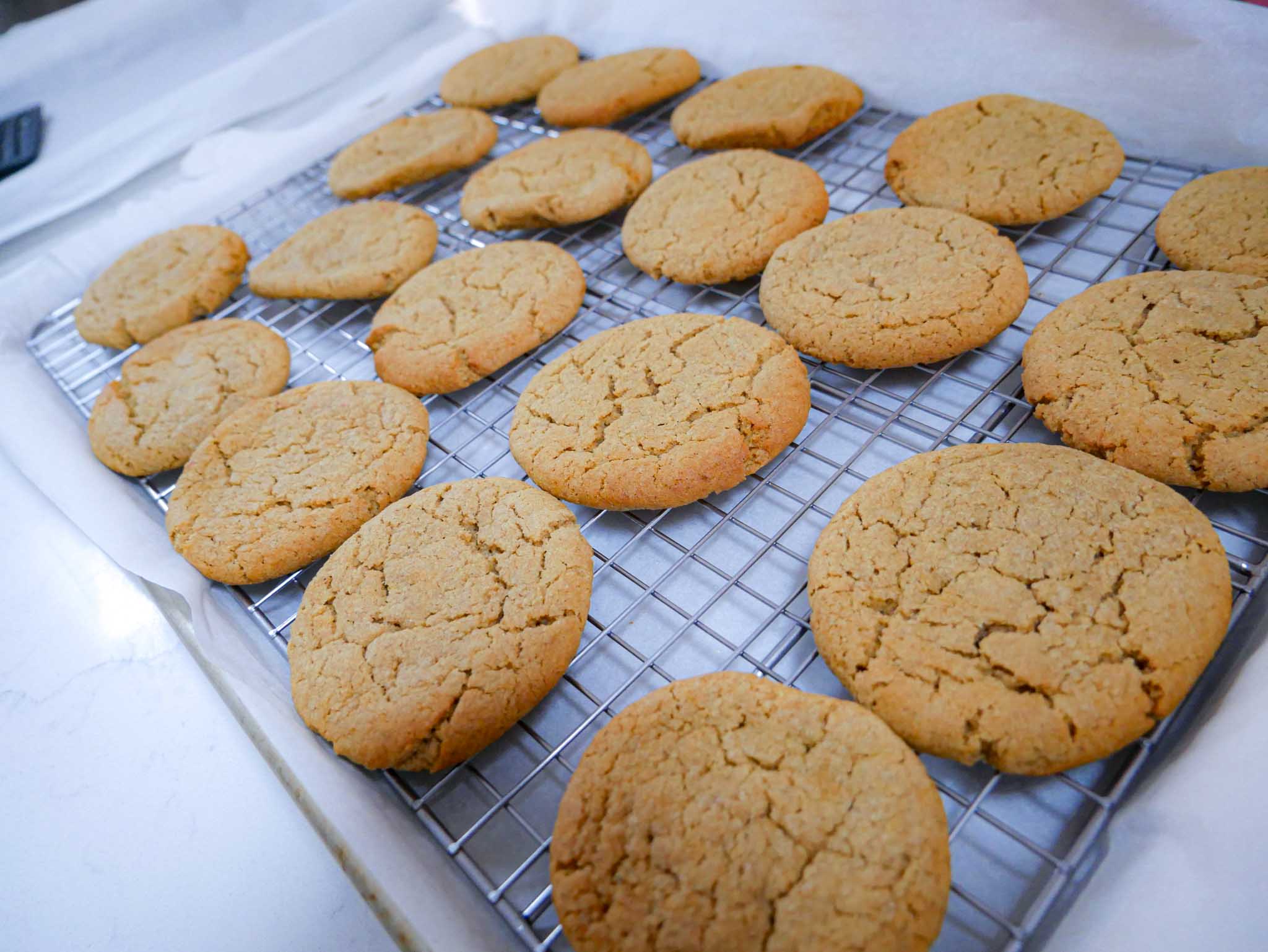 Mango Lassi cookies on a wire rack over parchment paper and a baking sheet, cooling after being baked.