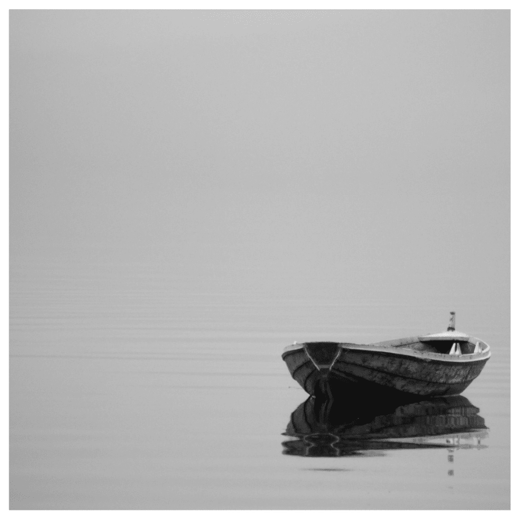 Boat on  water with nobody inside on in grayscale to signify feeling disconnected